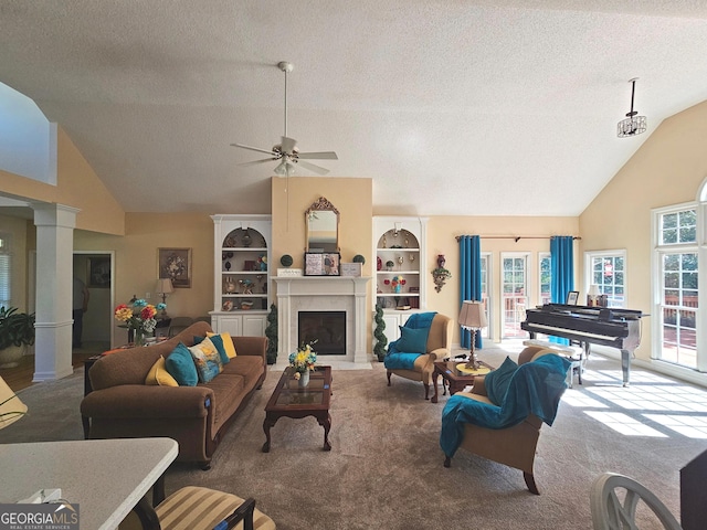 carpeted living room with a textured ceiling, high vaulted ceiling, ornate columns, and ceiling fan