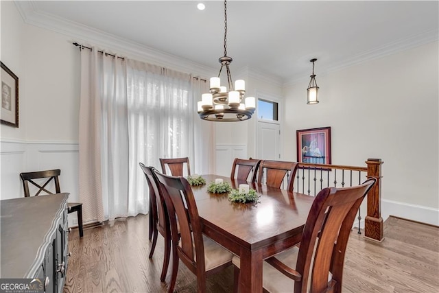 dining space featuring a notable chandelier, light hardwood / wood-style floors, and crown molding