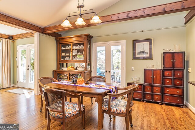 dining area featuring french doors, a wealth of natural light, lofted ceiling, and light hardwood / wood-style floors