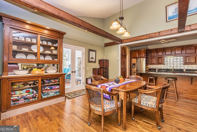 dining room with lofted ceiling with beams, light wood-type flooring, sink, and ceiling fan