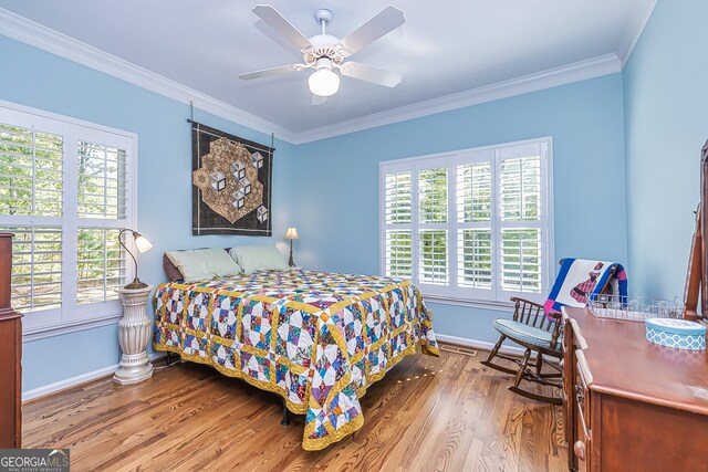 bedroom featuring multiple windows, hardwood / wood-style floors, ceiling fan, and crown molding