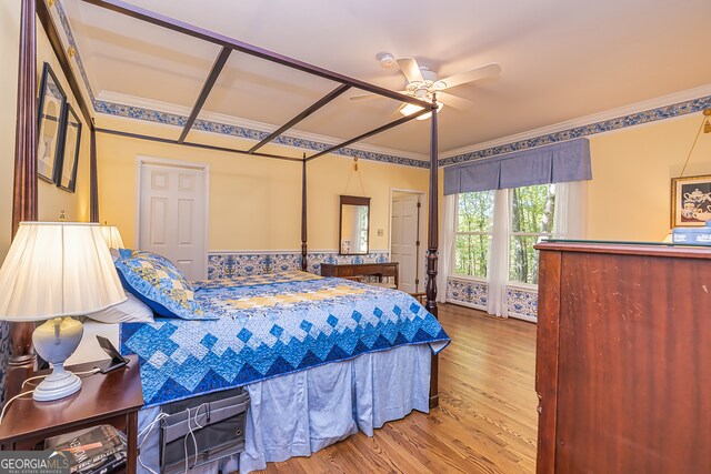 bedroom with ceiling fan, ornamental molding, and wood-type flooring