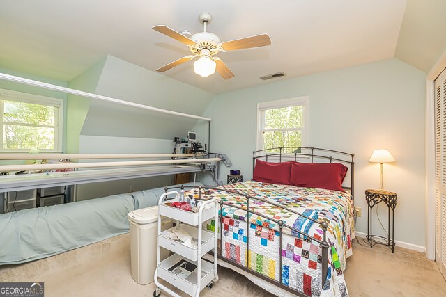 carpeted bedroom with a closet, lofted ceiling, and ceiling fan