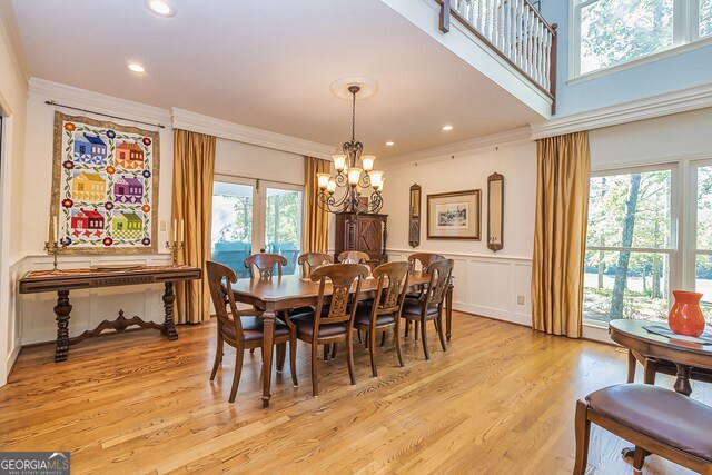 dining room with a healthy amount of sunlight, light hardwood / wood-style flooring, and crown molding