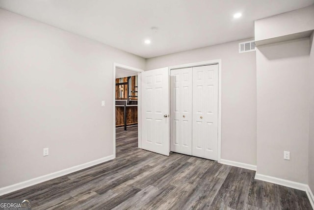 unfurnished bedroom with a closet and dark hardwood / wood-style floors