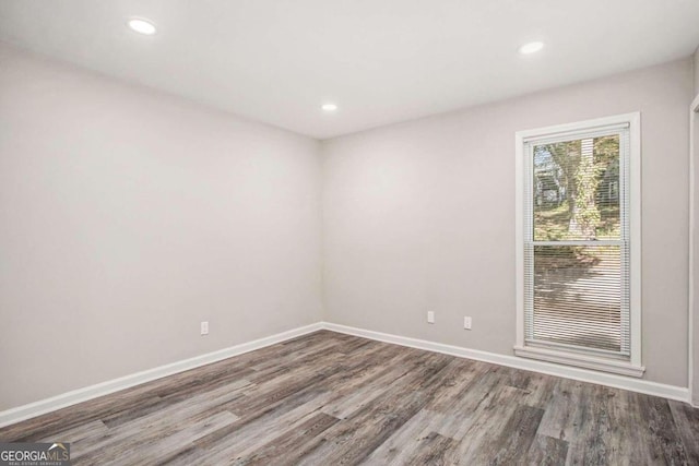 unfurnished room with hardwood / wood-style flooring