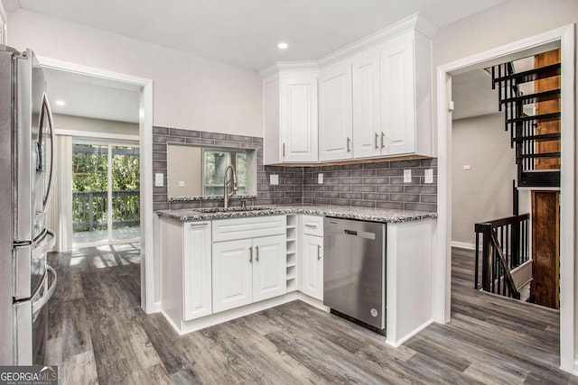 kitchen with white cabinets, stainless steel appliances, sink, and wood-type flooring