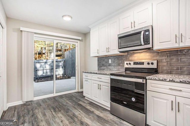 kitchen featuring appliances with stainless steel finishes, decorative backsplash, white cabinets, and dark wood-type flooring