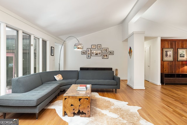 living room with vaulted ceiling with beams and light wood-type flooring