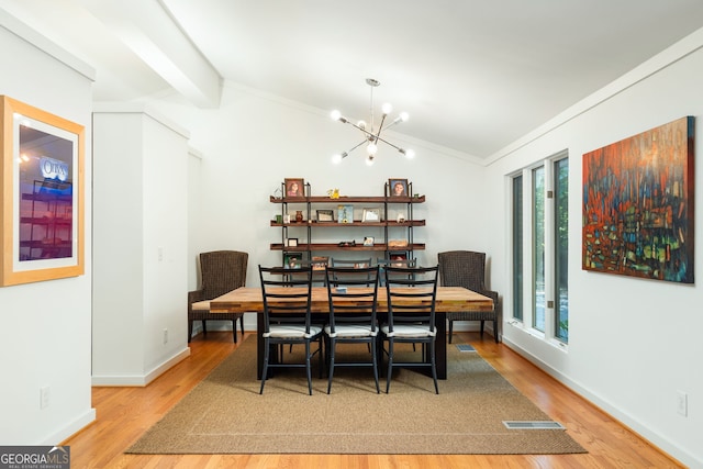 dining room with ornamental molding, a chandelier, vaulted ceiling with beams, and light hardwood / wood-style floors