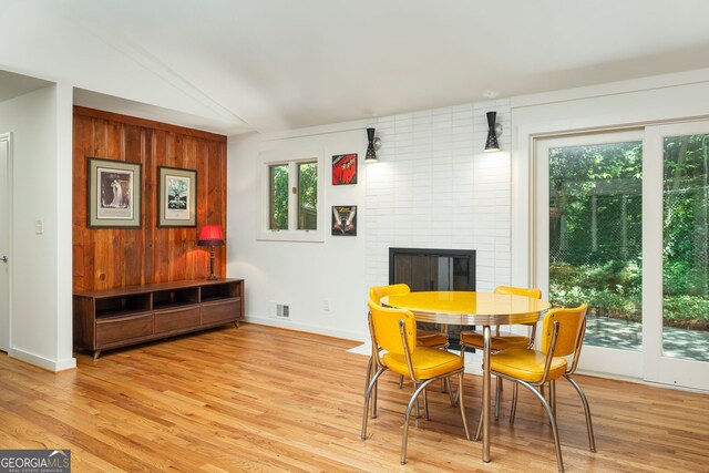 dining room featuring light hardwood / wood-style flooring and a large fireplace