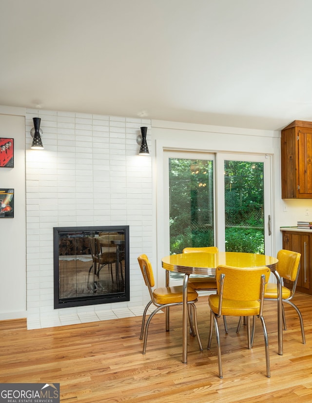 dining area featuring a large fireplace and light hardwood / wood-style flooring