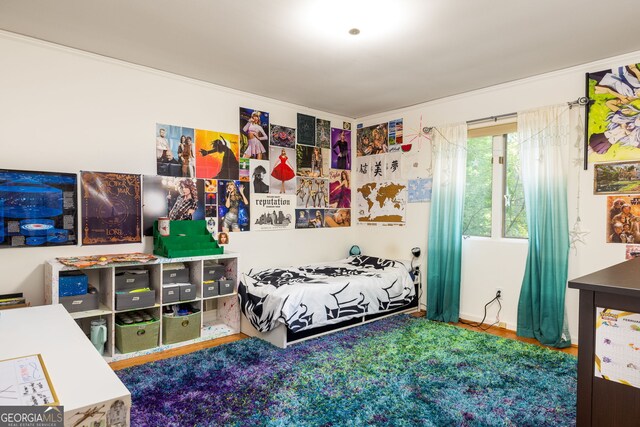 bedroom featuring crown molding and hardwood / wood-style flooring