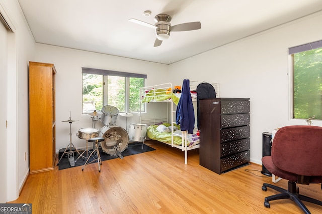 bedroom with light hardwood / wood-style floors and ceiling fan