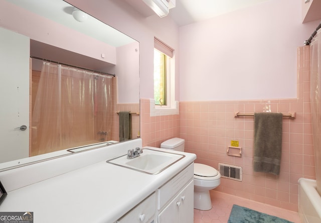 full bathroom with tile walls, vanity, shower / bath combination with curtain, and toilet