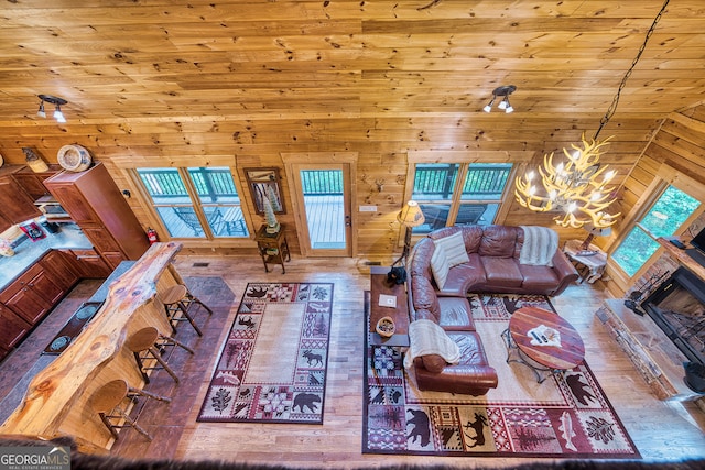 living room featuring lofted ceiling, wood walls, hardwood / wood-style flooring, and a wealth of natural light