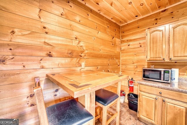 dining room featuring wooden walls and wood ceiling