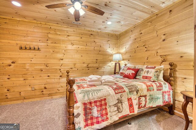 carpeted bedroom featuring wood ceiling, wooden walls, and ceiling fan