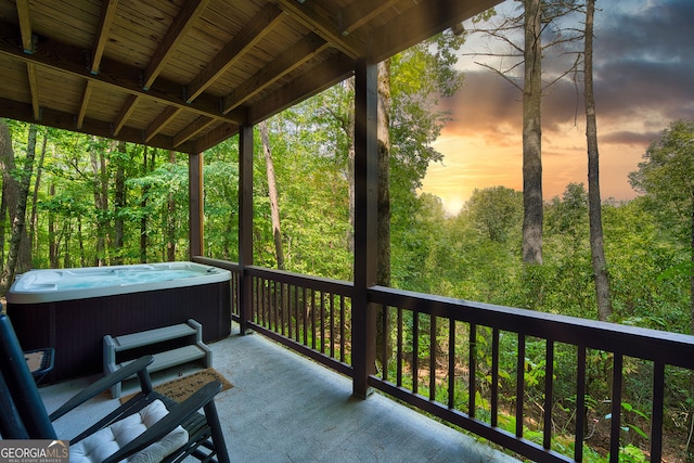 deck at dusk featuring a hot tub and cooling unit