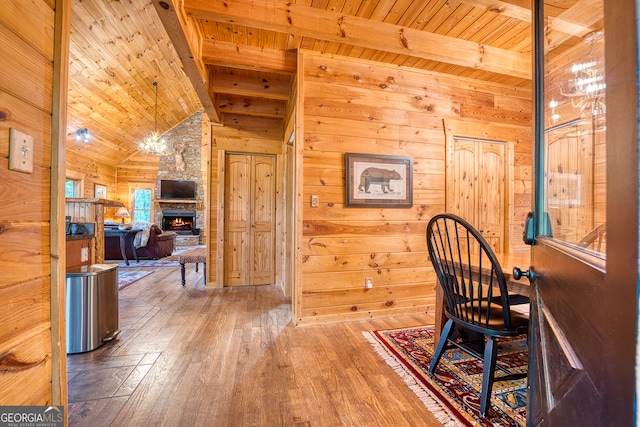 dining area with wooden walls, vaulted ceiling with beams, wood-type flooring, and wood ceiling