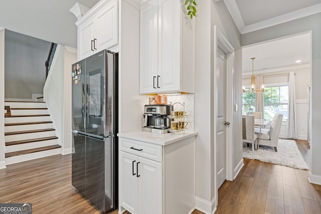 kitchen featuring fridge, ornamental molding, dark hardwood / wood-style flooring, white cabinets, and decorative backsplash