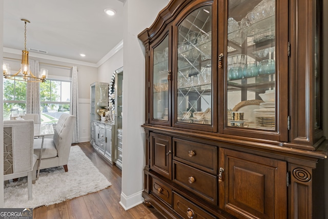 interior space with crown molding, a notable chandelier, and dark hardwood / wood-style floors