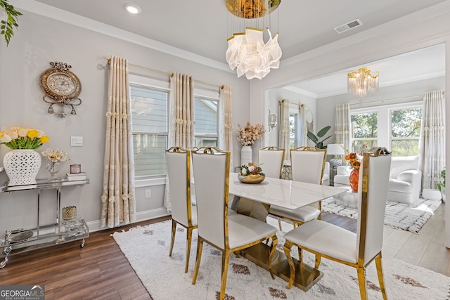 dining space with a chandelier, crown molding, and dark hardwood / wood-style flooring