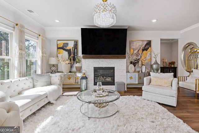 living room with a stone fireplace, dark hardwood / wood-style floors, and ornamental molding