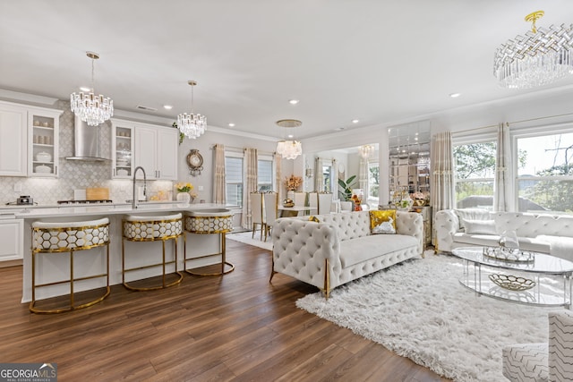 living room with ornamental molding, sink, and dark wood-type flooring