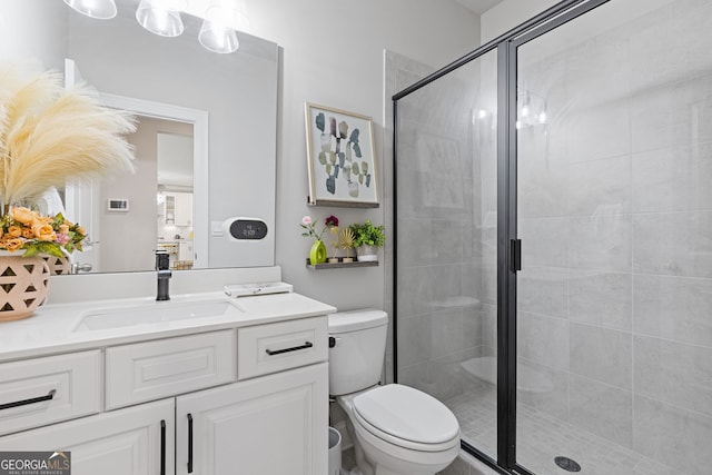 bathroom featuring vanity, toilet, and a shower with door