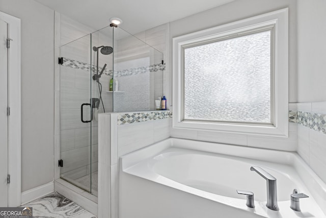 bathroom with a healthy amount of sunlight and independent shower and bath