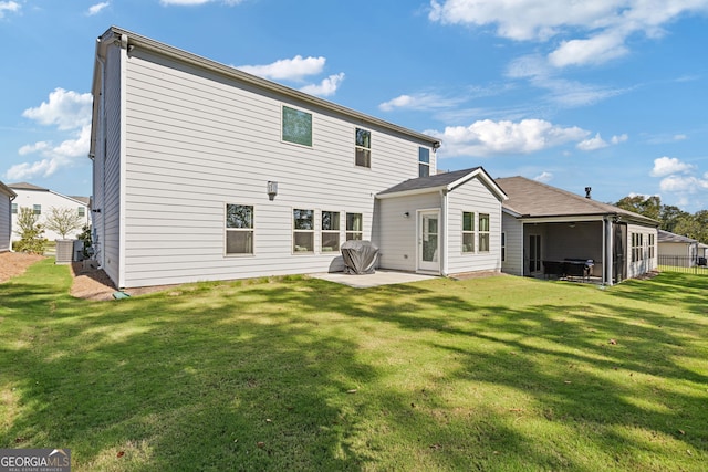 rear view of house featuring a patio area, central AC, and a lawn