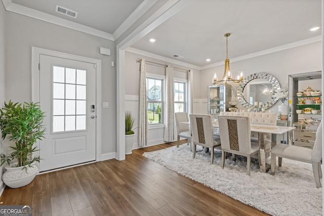 dining space with crown molding, a notable chandelier, and dark hardwood / wood-style flooring