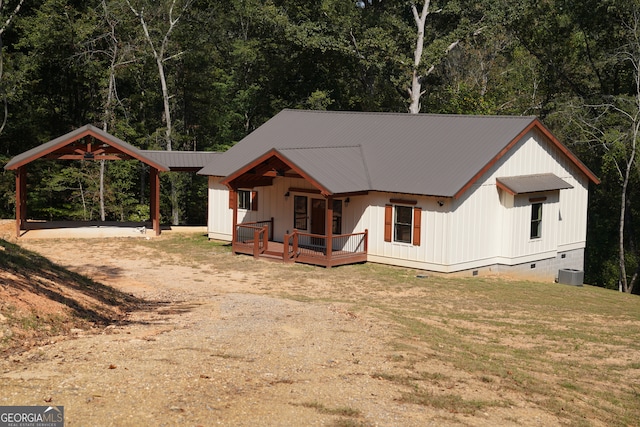 view of front facade featuring a wooden deck, cooling unit, and a front lawn