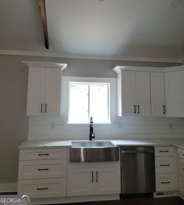 kitchen with beamed ceiling, white cabinetry, stainless steel dishwasher, and sink