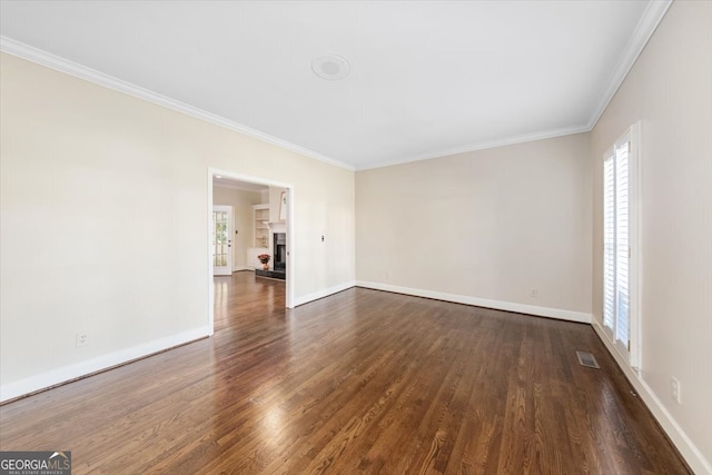 spare room featuring ornamental molding and dark wood-type flooring