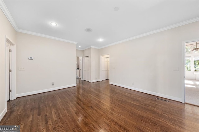 empty room with dark wood-type flooring and crown molding