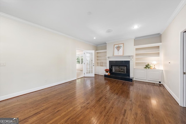 unfurnished living room featuring ornamental molding, dark wood-type flooring, built in features, and french doors