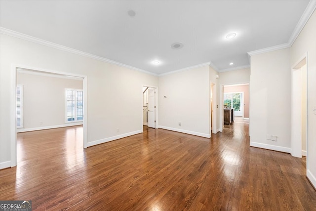 empty room with a wealth of natural light, ornamental molding, and dark hardwood / wood-style floors