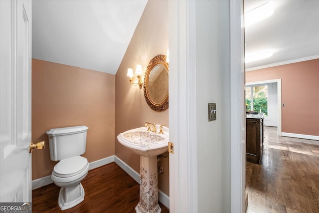 bathroom with toilet, lofted ceiling, hardwood / wood-style flooring, and crown molding