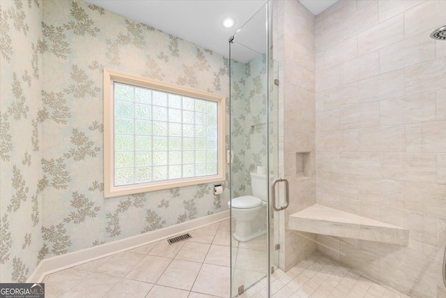 bathroom featuring tile patterned flooring, toilet, and an enclosed shower