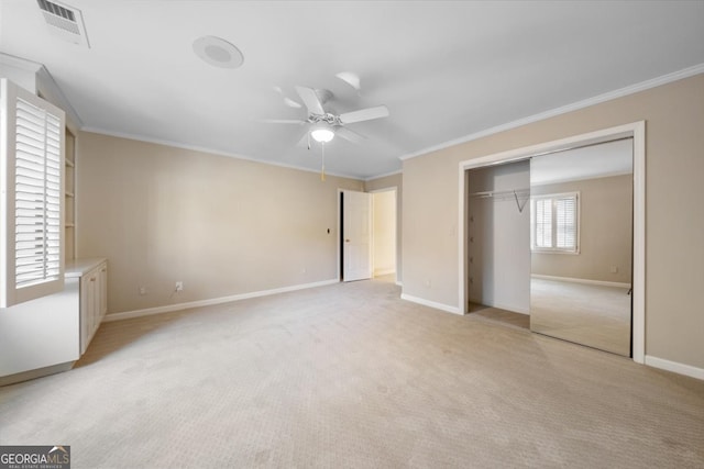 unfurnished bedroom featuring light carpet, a closet, crown molding, and ceiling fan