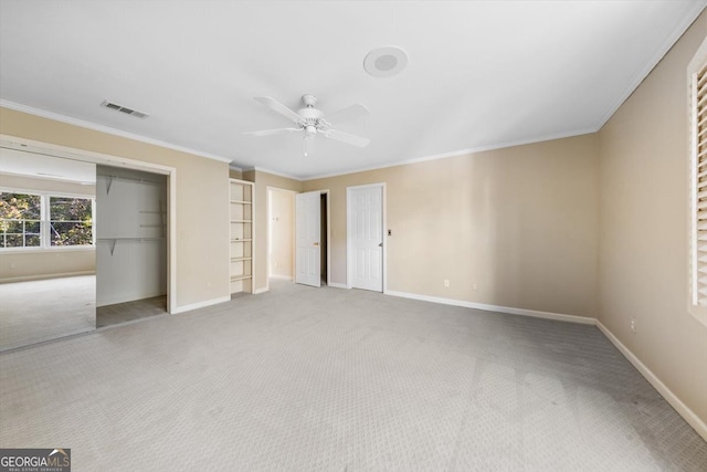 unfurnished bedroom featuring ornamental molding, light carpet, a closet, and ceiling fan