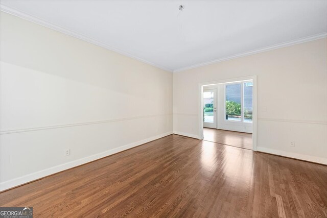 unfurnished room featuring crown molding and wood-type flooring