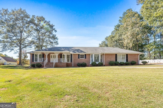 ranch-style home with covered porch and a front yard