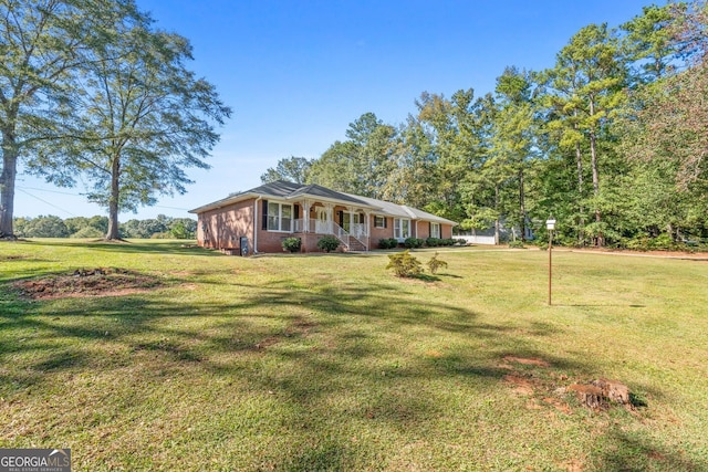 ranch-style house with covered porch and a front lawn