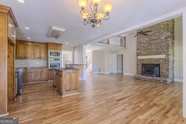 1201 Keencheefoonee Rd, Rutledge, GA 30663 - kitchen featuring ceiling fan with notable chandelier, brown cabinetry, open floor plan, stainless steel appliances, and light wood finished floors