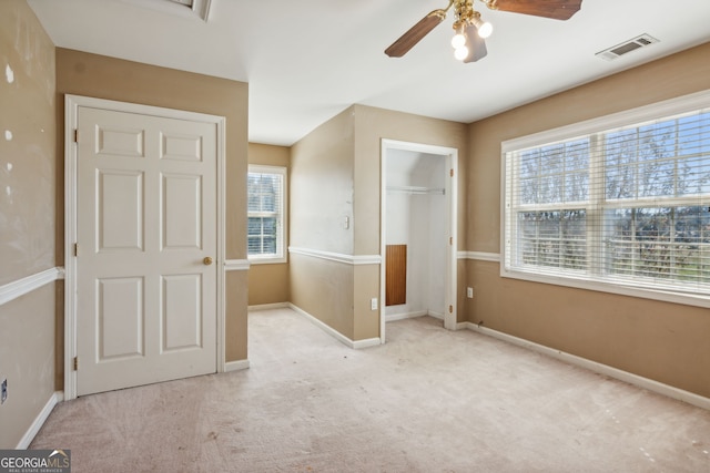 unfurnished bedroom with light carpet, a closet, and ceiling fan