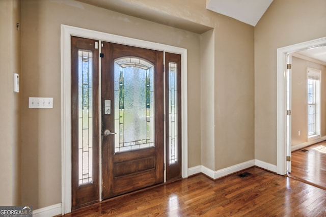 entrance foyer with dark wood-type flooring and vaulted ceiling