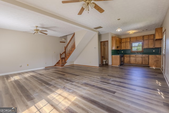 1201 Keencheefoonee Rd, Rutledge, GA 30663 - unfurnished living room with dark wood-style floors, visible vents, a sink, stairs, and ceiling fan
